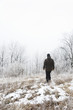 © Jovana Milanko/Stocksy - Young man walking trough the park covered in snow in the wintertime