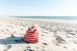 © Lea Jones/Stocksy - striped beach bag on sand