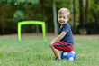 © jakob/Stocksy - Cute young boy sitting on a soccer ball