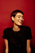 © leandro crespi/Stocksy - Beautiful and confident short haired woman portraits in her 30s shot in studio isolated over red background