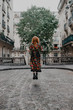 © Thais Ramos Varela/Stocksy - ginger oman wearing a floral dress jumps in the streets of paris