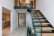 © Phillips Visuals/Stocksy - Entrance hall of a modern house with views of staircase, kitchen and hall.