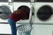 © Wavebreak Media - Woman doing laundry in laundromat