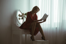 Studying Poetry. Sexy Woman Studying Poetry Sitting In Bedroom. Studying Poetry At Home. Girl In Red Dress Studying Poetry. Passionate Reader.