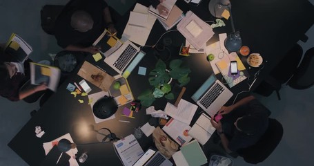 Wall Mural - top view diverse business people working late planning strategy team leader sharing documents for corporate project developing creative ideas in messy boardroom