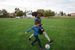 © Rob and Julia Campbell/Stocksy - Man and child (father son) playing soccer (football) together in