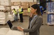 © Wavebreak Media - Female supervisor talking on mobile phone while using laptop