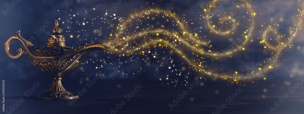 Image of magical mysterious aladdin lamp with glitter sparkle smoke over black background. Lamp of wishes. - obrazy, fototapety, plakaty 