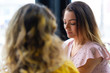 © Mangostar - Two young women chatting in cafe. One lady sitting back to camera. Women friendship and leisure concept.