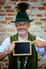 Wall Mural - bavarian man holding a black board