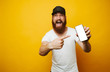 © Vulp - Amazed young bearded man in white t-shirt pointing at phone