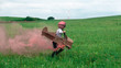 Cute little dreamer kid girl wearing pink helmet and aviator glasses flying in a cardboard airplane with attached smoke bombs through the field, pretending to be a pilot