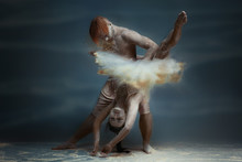 Dancing In Flour Concept. Girl Woman Female And Muscle Fitness Guy Man Male Couple In Love And In Relationship Making Dance Element Prefomance In Flour / White Dust On Isolated Black / Grey Background