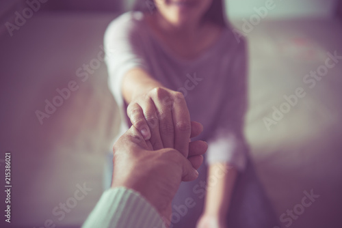 Fotografering Man giving hand to depressed woman,Psychiatrist holding hands patient such as ma