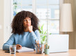 © Krakenimages.com - African american woman studying at home using a computer laptop serious face thinking about question, very confused idea