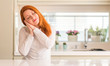 © Krakenimages.com - Redhead woman at kitchen sleeping tired dreaming and posing with hands together while smiling with closed eyes.