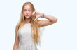 © Krakenimages.com - Blonde teenager woman with angry face, negative sign showing dislike with thumbs down, rejection concept