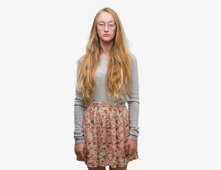 Sticker - Blonde teenager woman wearing flowers skirt with serious expression on face. Simple and natural looking at the camera.