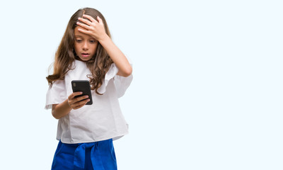 Poster - Brunette hispanic girl using smartphone stressed with hand on head, shocked with shame and surprise face, angry and frustrated. Fear and upset for mistake.