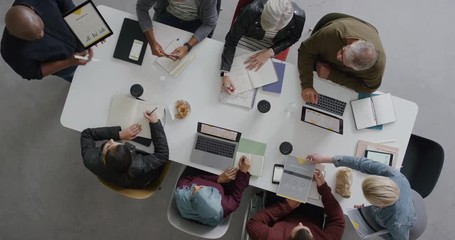Wall Mural - young african american businessman presenting corporate financial plan to colleagues in management meeting professional sharing market research overhead