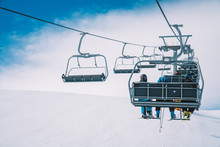 Ski Lefts And Cable Cars In The Alps Winter Resort. People Going Up For Skiing And Snowboarding. Austrian Alps
