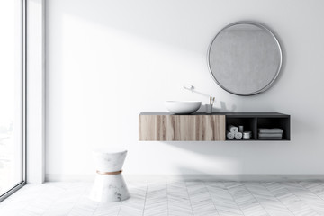 White bathroom with a round sink, mirror