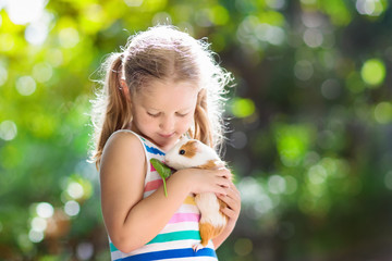 Child with guinea pig. Cavy animal. Kids and pets.