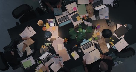 Wall Mural - multi ethnic business people working late planning strategy for corporate project developing creative ideas in messy boardroom above view