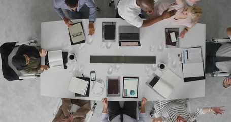 Wall Mural - happy african american businessman celebrating successful business deal high five colleagues cheerful executive team enjoying corporate success in boardroom top view