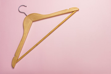 A wooden clothes hanger isolated on pink background