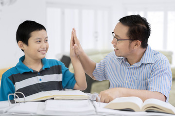 Wall Mural - Happy father doing high five with his son