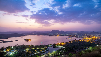 Wall Mural - Udaipur city at lake Pichola in the evening, Rajasthan, India. View from  the mountain viewpoint see the whole city reflected on the lake.