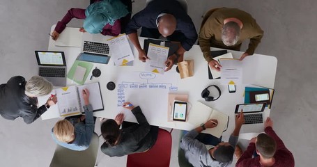 Wall Mural - top view young diverse team of web developers brainstorming ideas for startup business website planning design layout in modern office workspace time lapse rotate