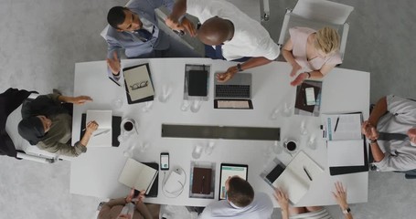 Wall Mural - happy african american businessman celebrating successful business deal high five colleagues cheerful executive team enjoying corporate success in boardroom top view