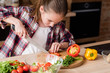 © golubovy - little cook. adolescent girl cutting vegetables and preparing dinner from fresh organic food ingredients. healthy eating and wholesome nutrition concept.