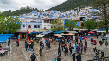 chefchaouen medina center with unidentified people, blue city skyline on the hill, morocco