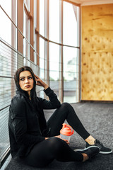 Wall Mural - Cute sporty girl sitting in the gym