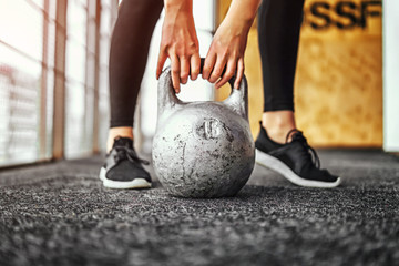 girl lifting kettlebell from the floor in the gym