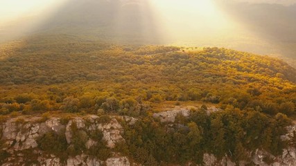 Poster - 4k uhd footage of drone flight over the rocky mountain cliff close up during summer sunset high above