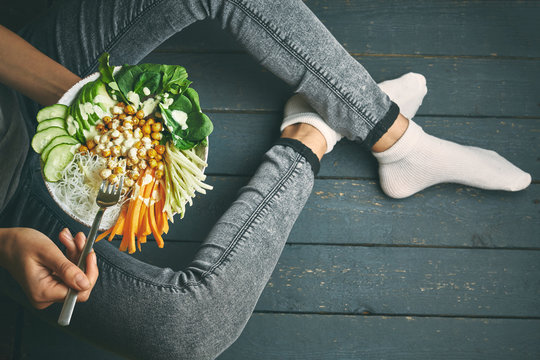 woman having healthy breakfast, raw vegan food in buddha bowl