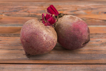 Fresh ripe beetroot close up. Fresh harvested beetroots, two homegrown organic beets ready for cooking. Wooden desk background.