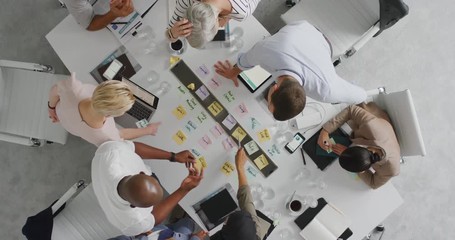 Wall Mural - diverse business people marketing team brainstorming ideas on successful financial solution planning strategy using colorful note paper in boardroom meeting top view