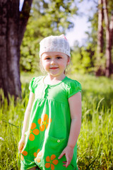 little girl in green dress in summer street