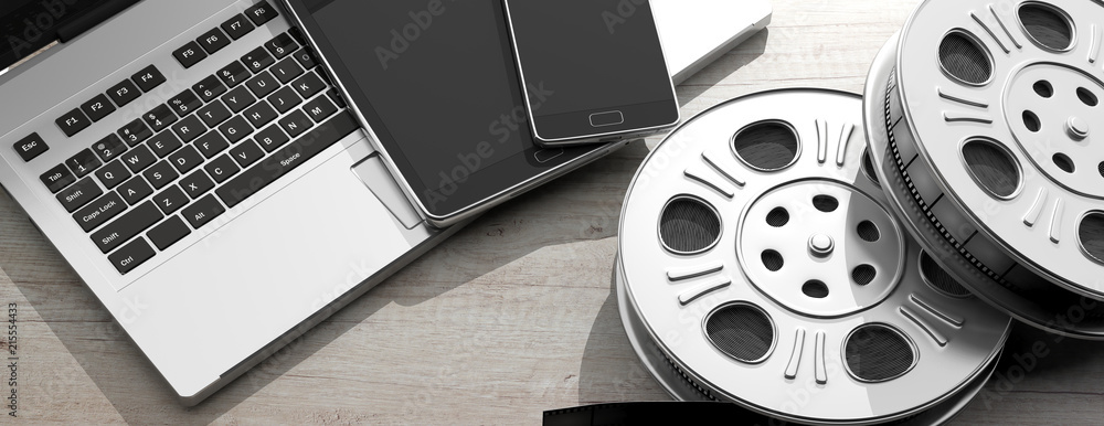 Film movie reels, laptop, tablet and smartphone, on a white wooden ...