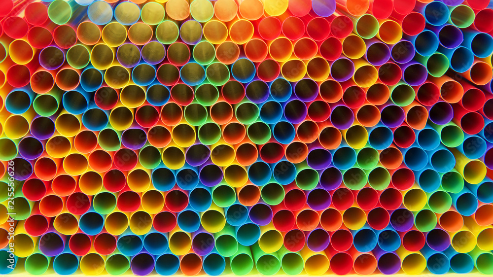 Hundreds of colorful plastic straws laying facing forwards opening ...