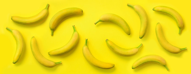Wall Mural - chaotic colorful fruit pattern. bananas over yellow background. banner. top view. pop art design, cr