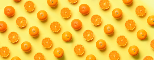 Wall Mural - fruit pattern of fresh orange slices on yellow background. top view. copy space. pop art design, cre