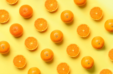 Wall Mural - fruit pattern of fresh orange slices on yellow background. top view. copy space. pop art design, cre