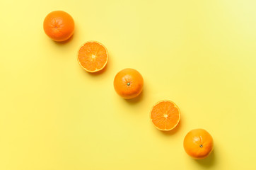 Wall Mural - fruit pattern of fresh orange slices on yellow background. top view. copy space. pop art design, cre