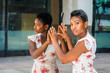 © Alexander Image - Young African American Woman with short afro hairstyle, standing by mirror in New York, hands touching reflections, head turning around, thinking. Concept of self assured, self esteem, self checking.